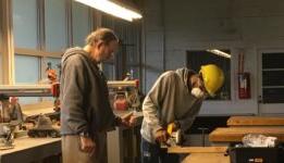 Instructor working with student on usuing a table saw